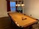 Basement with wooden floors and a pool table with overhead lighting, and a playroom set-up in the background at 16119 E Prentice Ln, Centennial, CO 80015