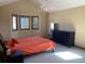 A bedroom with a neutral palette, a bed, and a dark dresser with multiple windows that provide natural light at 16119 E Prentice Ln, Centennial, CO 80015