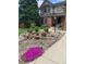 Charming two-story brick home featuring a beautifully landscaped front yard with colorful flowers and lush greenery at 16119 E Prentice Ln, Centennial, CO 80015