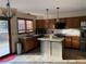 Well-lit kitchen with an island, stainless steel appliances, wood cabinets, and a view to the backyard at 16119 E Prentice Ln, Centennial, CO 80015