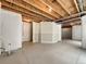 Unfinished basement showcasing exposed wooden beams, concrete floor, and insulated walls ready for customization at 2258 Whistler Dr, Longmont, CO 80504