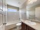 Bright bathroom featuring a tub with shower, a window for natural light, and a vanity with a white sink at 2258 Whistler Dr, Longmont, CO 80504