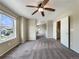 Bright, neutral-toned, carpeted bedroom with ceiling fan and window overlooking neighborhood at 2258 Whistler Dr, Longmont, CO 80504