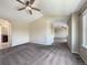 Upstairs carpeted bedroom with vaulted ceiling, ceiling fan, and window overlooking neighborhood at 2258 Whistler Dr, Longmont, CO 80504