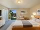 Virtually staged main bedroom with a large bed and sliding glass doors leading to a balcony at 750 Tabor St # 18, Lakewood, CO 80401