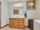 Functional bathroom with a wooden vanity, framed mirror, and ceramic tile, providing a blend of utility and traditional style at 12348 Quartz Spur, Conifer, CO 80433
