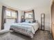 Relaxing bedroom with a king-size bed, large windows with nature views, and warm carpet flooring at 12348 Quartz Spur, Conifer, CO 80433