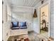 Cozy mudroom with bench seating, coat hooks, a unique wood-panelled wall, and an adjacent workout room at 12348 Quartz Spur, Conifer, CO 80433