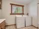Well-equipped laundry room featuring a window, a standard washer and dryer for easy chore management at 12348 Quartz Spur, Conifer, CO 80433
