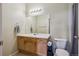 Bright bathroom with a wooden vanity, large mirror, and a neutral color scheme at 14221 E 1St Dr # 208, Aurora, CO 80011