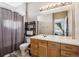 Bathroom with wooden vanity, tiled floors, and a shower with curtain rod at 14221 E 1St Dr # 208, Aurora, CO 80011