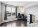 Versatile room with dark wood floors, large window, and a dedicated workstation area at 14221 E 1St Dr # 208, Aurora, CO 80011
