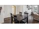 Open dining room with dark wood floors, black dining set, and decorative wall shelving at 14221 E 1St Dr # 208, Aurora, CO 80011