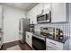 Well-equipped kitchen with stainless steel appliances and black-and-white backsplash at 14221 E 1St Dr # 208, Aurora, CO 80011