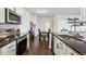 Full kitchen featuring stainless steel appliances, dark countertops and flooring, with a view to the dining area at 14221 E 1St Dr # 208, Aurora, CO 80011