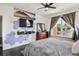 Bedroom showcasing a mounted TV, large window, dark floors, and a comfortable bed at 14221 E 1St Dr # 208, Aurora, CO 80011