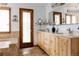 Bright bathroom with double sink vanity, tiled floors, a soaking tub, and an exterior access door at 8626 Junco Trl, Evergreen, CO 80439