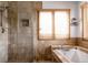Nicely appointed bathroom showcasing glass enclosed shower, soaking tub, and natural stone tile at 8626 Junco Trl, Evergreen, CO 80439