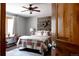 Inviting bedroom with stylish wood wall decor, a ceiling fan, and large window, creating a relaxing retreat at 8626 Junco Trl, Evergreen, CO 80439