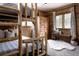 Cozy wood-paneled bedroom offers bunk beds, ample closet space, and a comfortable sitting area at 8626 Junco Trl, Evergreen, CO 80439