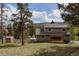 Inviting two-story home with a charming pergola, shed and lush greenery in a serene outdoor setting at 8626 Junco Trl, Evergreen, CO 80439