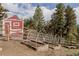 Outdoor garden area featuring raised garden beds and a charming red outbuilding at 8626 Junco Trl, Evergreen, CO 80439
