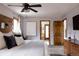 Comfortable main bedroom with wood accent headboard, ceiling fan, and a connected bathroom with shower at 8626 Junco Trl, Evergreen, CO 80439