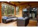 Covered porch with comfortable seating and wooded views at 8626 Junco Trl, Evergreen, CO 80439