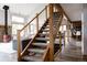 Staircase with wood railing and metal wire accents leading to an open-concept living area and kitchen at 8626 Junco Trl, Evergreen, CO 80439