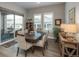 Cozy dining room featuring wood floors, a large window, and access to the outdoor patio via sliding glass doors at 8548 S Quatar St, Aurora, CO 80016