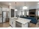 Open-concept kitchen with stainless steel appliances and granite countertops flowing into the living room at 8548 S Quatar St, Aurora, CO 80016
