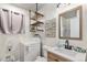 Bathroom including a sink, toilet, washer, dryer, and floating shelves at 309 S 30Th Ave, Brighton, CO 80601