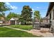 Green backyard with a deck and a large tree near a shed-style garage with a carport at 1455 Hudson St, Denver, CO 80220