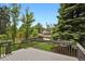 View of the backyard from the porch overlooking the lawn, trees, and nearby houses at 1455 Hudson St, Denver, CO 80220