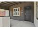 Covered front porch with dark painted brick, a modern light fixture, and concrete flooring at 1455 Hudson St, Denver, CO 80220