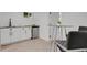 A modern wet bar with light wood floors, white cabinets, and black accents at 1455 Hudson St, Denver, CO 80220