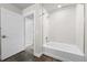 Modern bathroom with a shower-tub combo, white tile surround, and dark floor, complemented by bright lighting at 20 Wilcox St # 318, Castle Rock, CO 80104