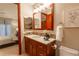 Charming bathroom features wood cabinets, decorative backsplash, and a view into the bedroom at 2800 S University Blvd # 184, Denver, CO 80210