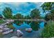 A serene pond reflects the surrounding homes and mature trees at 2800 S University Blvd # 184, Denver, CO 80210