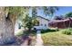 Backyard view featuring a detached garage, mature trees, and a well-maintained lawn at 4430 S Cherokee St, Englewood, CO 80110