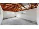 Basement with exposed ceiling beams, concrete floor, and access door at 4430 S Cherokee St, Englewood, CO 80110