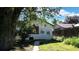 Charming home with a door and window surrounded by green grass and a large tree at 4430 S Cherokee St, Englewood, CO 80110