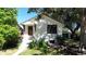 Charming home exterior featuring a white facade, dark trim, and well-maintained landscaping at 4430 S Cherokee St, Englewood, CO 80110