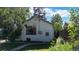 Charming home with a door and window surrounded by green grass and lush trees at 4430 S Cherokee St, Englewood, CO 80110