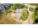 Aerial shot of a property with mature trees, a detached garage, and landscaping including green grass and shrubs at 1245 S Willow St, Denver, CO 80247