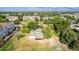 An aerial view of a property, featuring a grassy yard and a detached garage, surrounded by mature trees at 1245 S Willow St, Denver, CO 80247