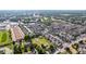 A high-angle view of a neighborhood featuring closely spaced homes, mature trees, and nearby commercial buildings at 1245 S Willow St, Denver, CO 80247