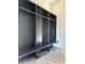 A mudroom with custom, dark gray shelving and bench area provides practical storage at 65960 E Evans Pl, Byers, CO 80103