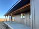 A covered porch and walkway provide covered access on the side of this modern home at 65960 E Evans Pl, Byers, CO 80103