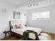 Sun-filled bedroom showcasing a tufted headboard, a cozy full bed, and warm hardwood floors at 1459 S Filbert Way, Denver, CO 80222